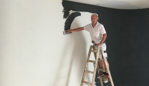 Malermeister Marco Ludwig beim Verputzen einer Wand.